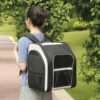 Frau die einen schwarzen Katzenrucksack trägt